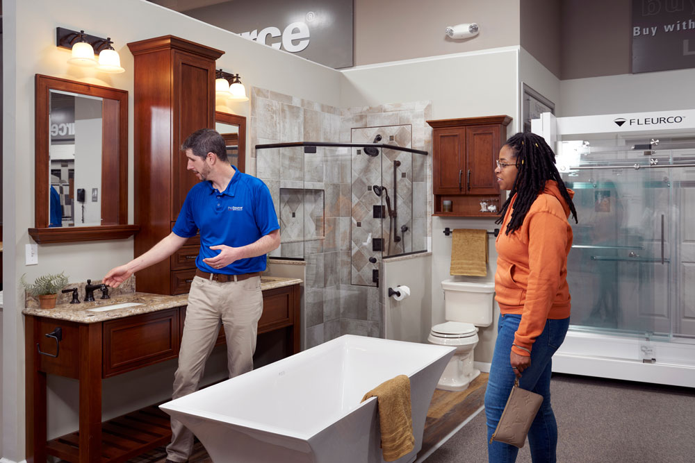 Employee showing bathroom upgrade options to a young lady