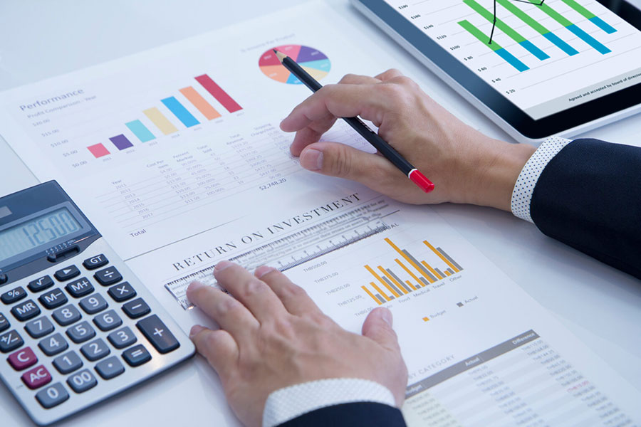 An office worker looking at data sheets with a calculator