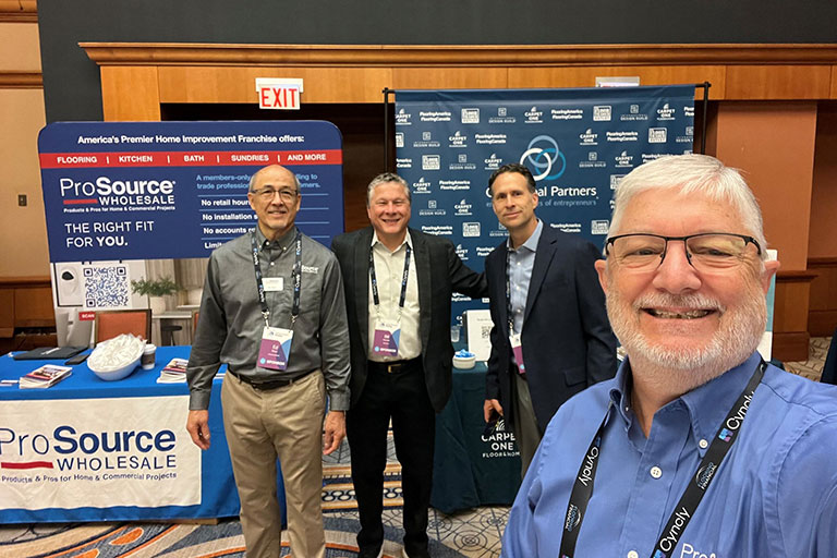 Four men standing in front of a ProSource booth