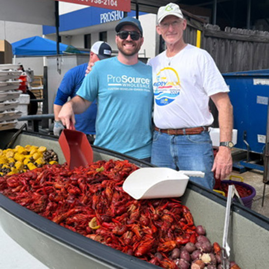 Two men smiling at a crawfish boil