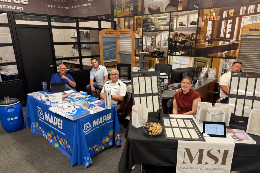 Vendor tables set up in showroom. Venders smiling ate the camera